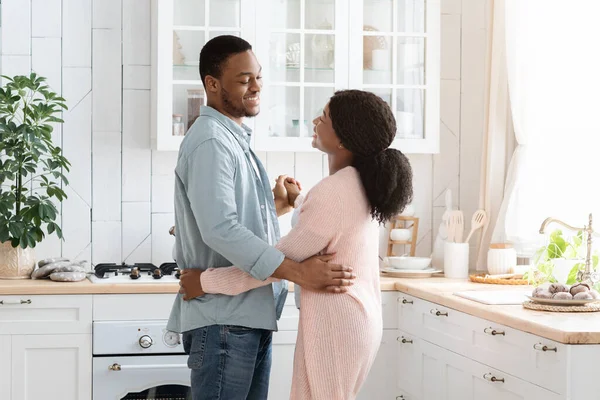 Casais Vida Doméstica. Amando cônjuges negros dançando na cozinha acolhedora em casa — Fotografia de Stock