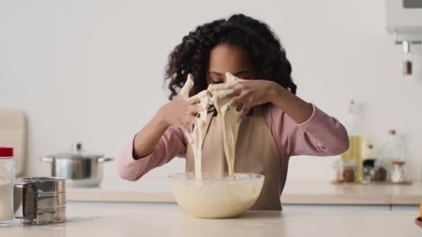 I primi biscotti fatti in casa. carino sporco poco africano americano ragazza impastare pasta in ciotola, cercando di cuocere pasticceria stessa — Video Stock