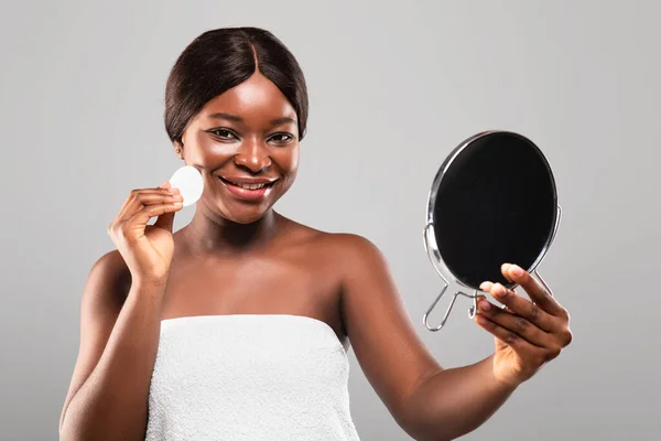 Rotina da Beleza. Africano Feminino Segurando Espelho de Aumento, Limpando Rosto Com Almofada De Algodão — Fotografia de Stock