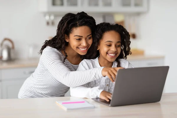 Smiling african american mom hugging her studying kid, copy space