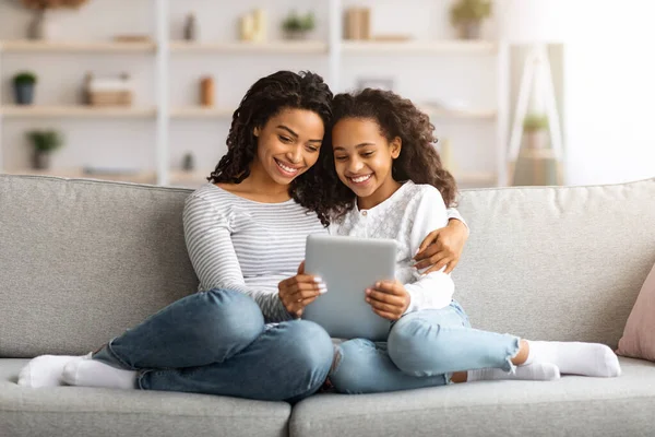 Niedliche afrikanische Mutter und Tochter lesen Bücher auf digitalem Tablet — Stockfoto