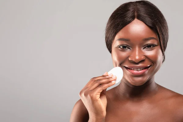 Limpeza da pele. Cara de limpeza feminina afro-americana sorridente com almofada de algodão, close-up — Fotografia de Stock