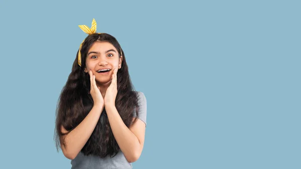 Ενθουσιασμένος Ινδός έφηβος άνοιγμα στόμα σε ενθουσιασμό, thouching πρόσωπο, δεν μπορεί να πιστέψει μεγάλη πώληση ή promo σε μπλε φόντο — Φωτογραφία Αρχείου