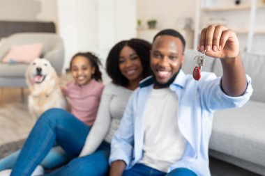 Mutlu siyah aile yeni evlerinin anahtarlarını gösteriyor.