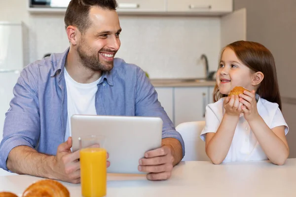 Pai e filha usando tablet digital desfrutando de almoço juntos dentro de casa — Fotografia de Stock