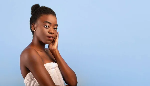 Efter spa. Vacker svart kvinna med perfekt glödande hud tittar på kameran efter skönhetsbehandling, blå bakgrund — Stockfoto