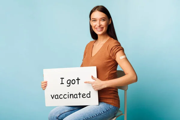 Zwangere dame houdt poster Ik kreeg gevaccineerd op blauwe achtergrond — Stockfoto