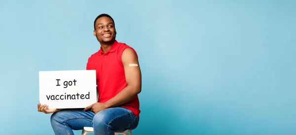 Africano chico sosteniendo cartel me vacuné sobre fondo azul — Foto de Stock
