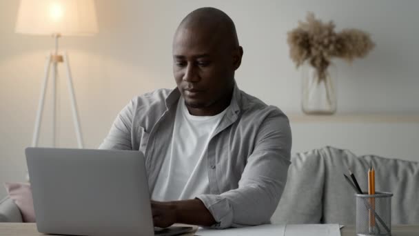 African American Man Using Laptop Working Online Sitting At Home — Vídeo de stock