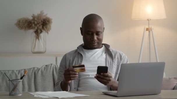 Black Man Using Phone And Credit Card Shopping Online Indoor — Vídeo de Stock