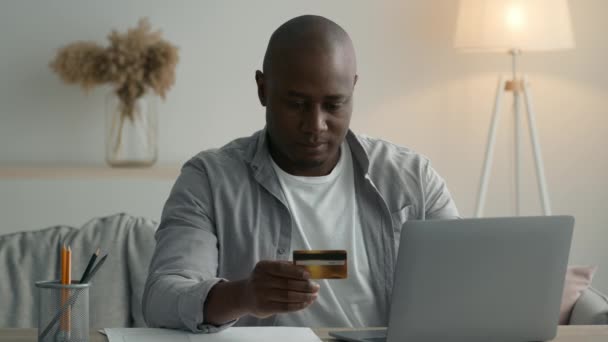 Preto homem compras usando laptop e cartão de crédito em casa — Vídeo de Stock