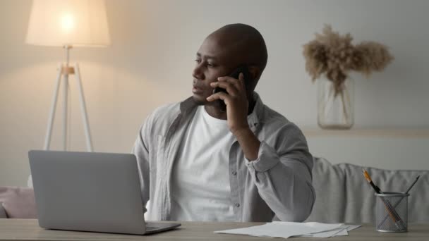 Serius Black Man Berbicara Pada Nodding Telepon Kepala di Rumah — Stok Video