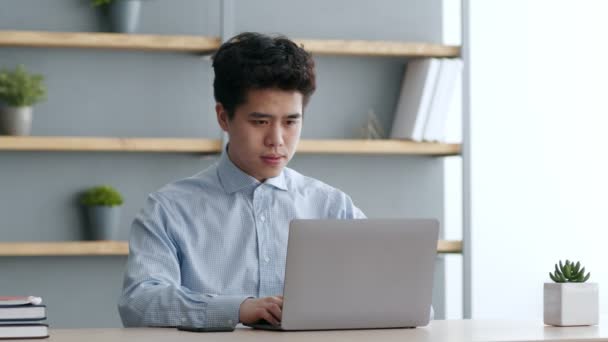 Buenas noticias. Joven asiático chico trabajando en portátil en línea, escribiendo y recibiendo correo electrónico con la información ganadora, sintiéndose emocionado — Vídeo de stock