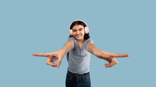 Enjoy music. Happy Indian teeneger girl listening to her favorite sountrack, using wireless headphones and dancing — Stock Photo, Image