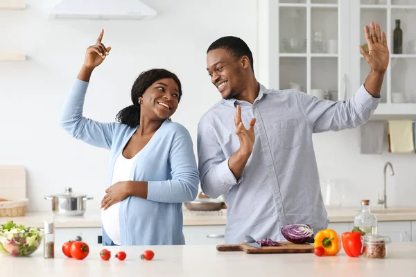 Positivo grávida preto casal se divertindo enquanto cozinha — Fotografia de Stock