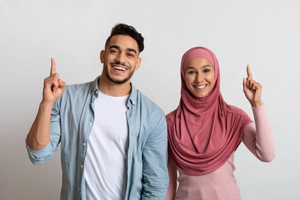 Idea Concept. Veselý mladý muslimský pár ukazuje prsty nahoru — Stock fotografie