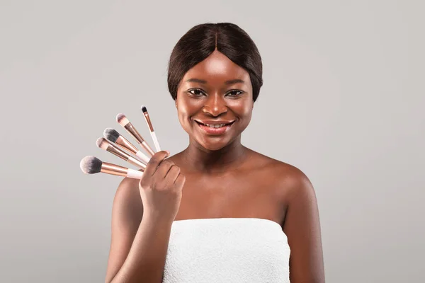 Makyaj Konsepti. Gülümseyen Afrikalı bir kadın makyaj fırçası seti tutuyor., — Stok fotoğraf