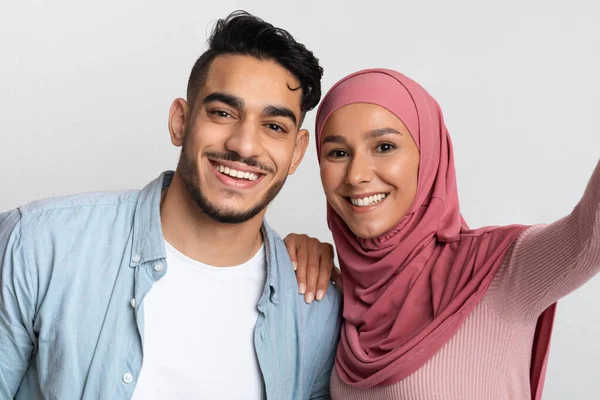Šťastný mladý Arab muž a muslim žena v hidžábu přičemž selfie spolu — Stock fotografie