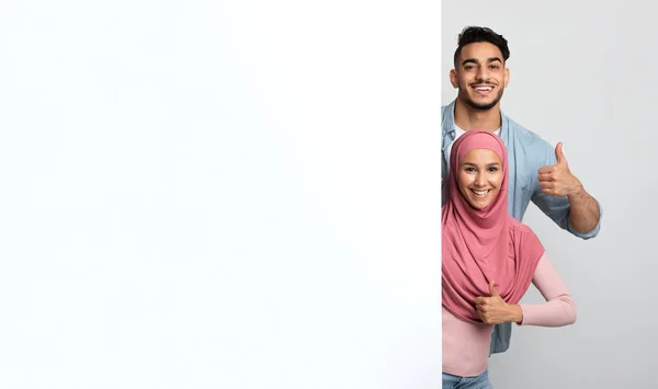 하얀 백지 광고판을 보고 손가락들이 보이는 이슬람 배우자들 — 스톡 사진