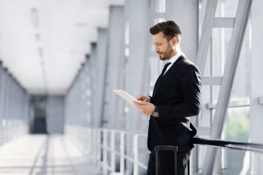 Yakışıklı sakallı iş adamı uçuş için ped kullanıyor.