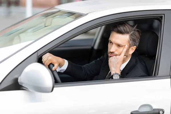 Hoffnungsloser Geschäftsmann mittleren Alters fährt Auto und steckt im Verkehr fest — Stockfoto