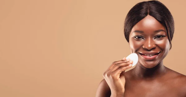 Conceito de Cuidados com a pele. Linda mulher afro-americana cara de limpeza com almofada de algodão — Fotografia de Stock