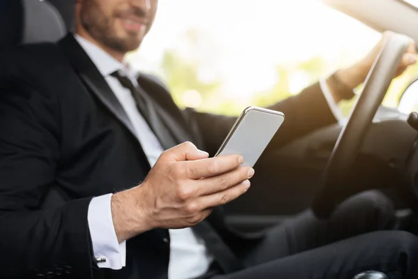 Beskärs av affärsman som kör bil, med mobiltelefon — Stockfoto