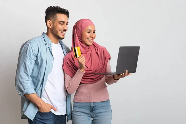 Felice giovane coppia islamica Shopping online con computer portatile e carta di credito — Foto Stock