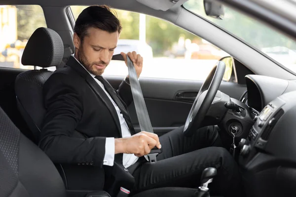 Geschäftsmann im Anzug schnallt Sicherheitsgurt in seinem Auto an — Stockfoto