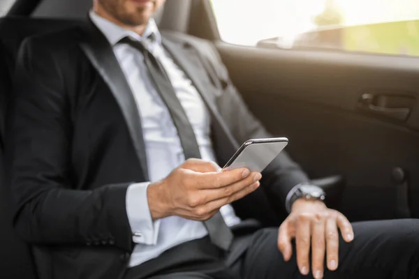 Manager sitzt im Auto und nutzt Smartphone — Stockfoto