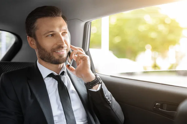 Glada VD talar i telefon när du går med bil — Stockfoto