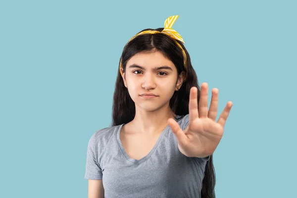 Muchacha adolescente india seria haciendo un gesto PARADA en el fondo del estudio azul. Concepto de dictamen negativo —  Fotos de Stock