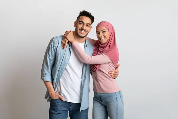 Ifjú iszlám család. Boldog muszlim házastársak ölelkező és mosolygó a kamera — Stock Fotó