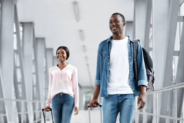 Retrato de gente negra feliz caminando en la terminal del aeropuerto con maletas — Foto de Stock