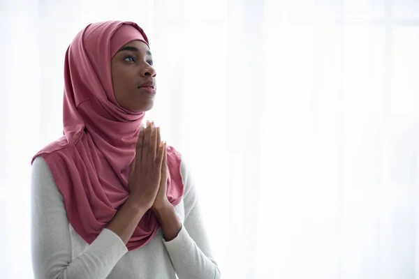 Giovane donna musulmana nera in rosa Hijab pregando Allah con le mani catapultate — Foto Stock
