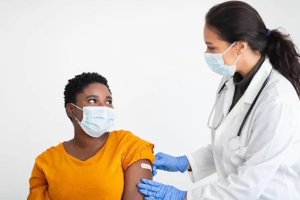 Afrikaanse vrouw krijgt vaccin tegen Covid-19 op witte achtergrond — Stockfoto