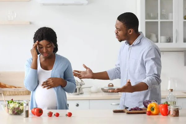 Embarazada mujer negra luchando con su marido mientras cocinan juntos — Foto de Stock