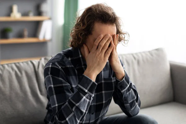 Ragazzo infelice che copre il viso che soffre di depressione seduto a casa — Foto Stock