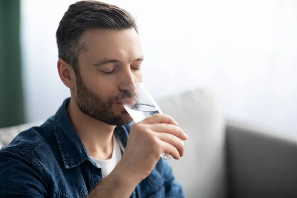 Primo piano dell'uomo barbuto che beve acqua a casa — Foto Stock
