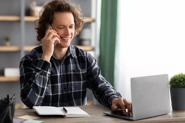 Empresário alegre conversando no celular sentado no local de trabalho no escritório — Fotografia de Stock