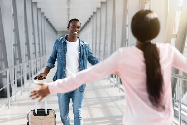 Unerkennbare schwarze Frau trifft ihren Freund nach seiner Ankunft im Flughafen — Stockfoto