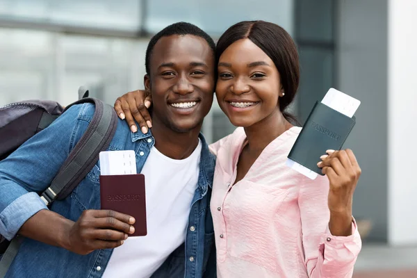 Pareja de viajeros. Feliz hombre negro y mujer posando con pasaportes y boletos — Foto de Stock