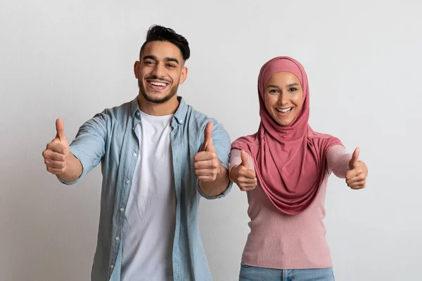 Vidám fiatal közel-keleti pár felmutatva hüvelykujját a kamera előtt — Stock Fotó