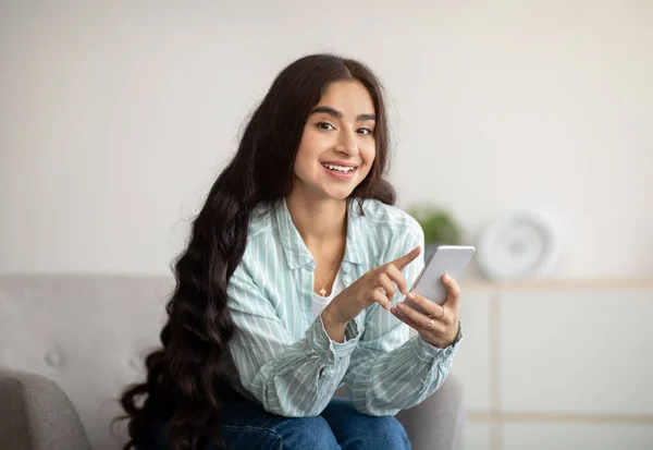 Красивая индийская женщина с помощью смартфона, проверяя электронную почту, общаясь с другом онлайн дома — стоковое фото