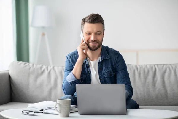 Homem alegre freelancer trabalhando em casa, usando laptop — Fotografia de Stock