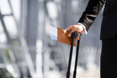 Pasaport ve biletleri elinde tutan tanınmamış bir işadamı.