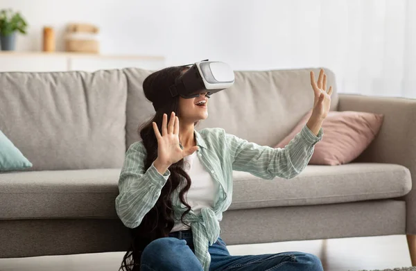 Mujer india milenaria en gafas de realidad virtual explorando el ciberespacio, jugando videojuegos interactivos en interiores — Foto de Stock