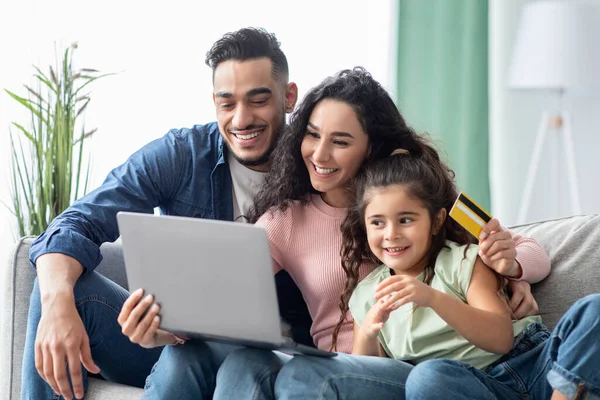Famiglia mediorientale di tre persone con computer portatile e carta di credito a casa — Foto Stock