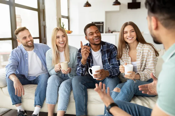 Miltiethnie jeunes amis ayant un rassemblement social, parler et rire, boire du thé ou du café à la maison — Photo