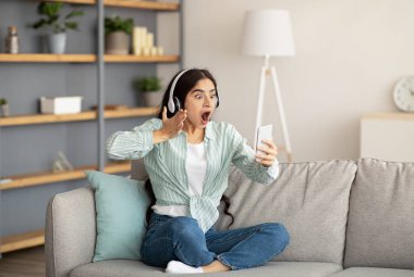 Şok olmuş Hintli kadın akıllı telefondan duygusal iletişim kuruyor, evdeki web kamerasına bağırıyor.